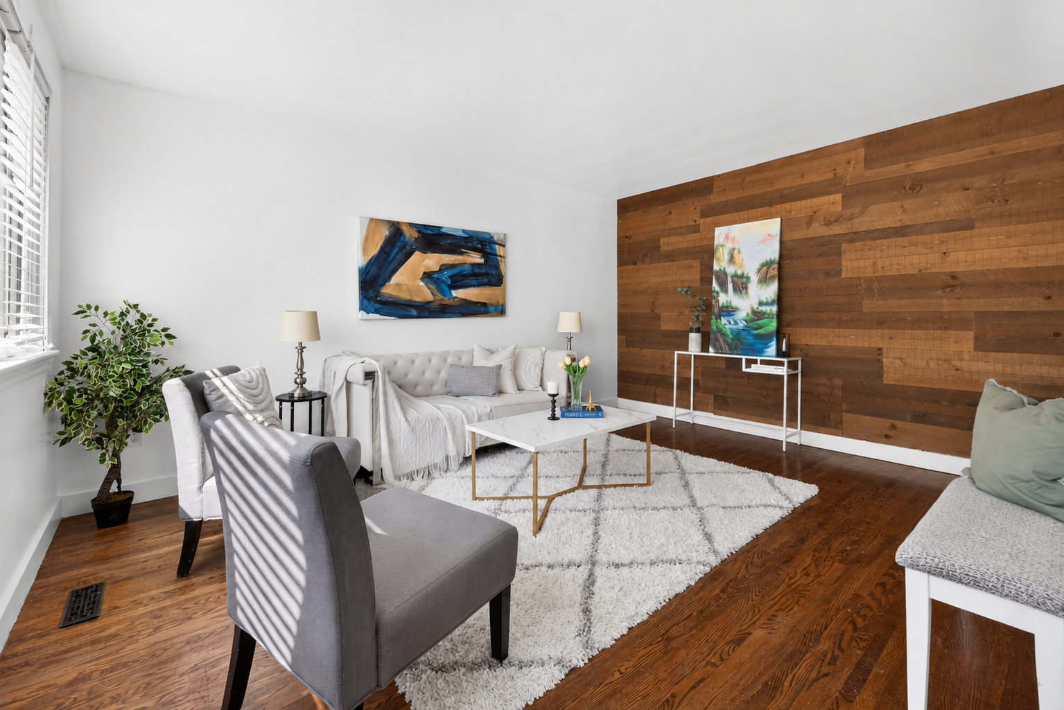Main-floor living room at 754 Crawford Place in Peterborough with hardwood flooring, natural light and a wood accent wall.